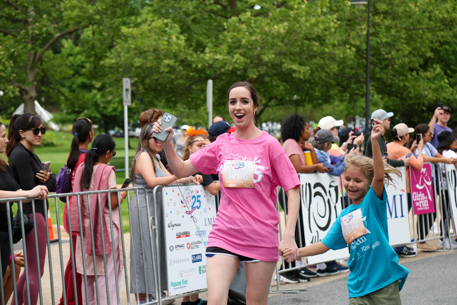 Group of Girls on the Run participants and coaches doing a cheer at Camp GOTR.
