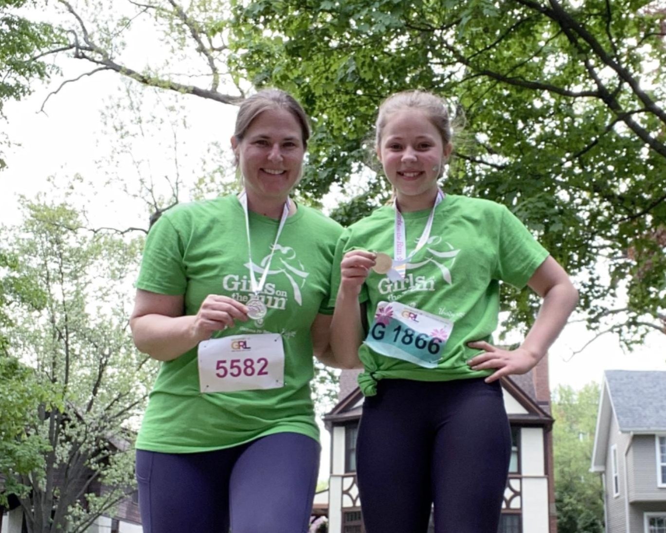 Emily Milman and her daughter wearing GOTR t-shirts, smiling and posing with their 5K medals