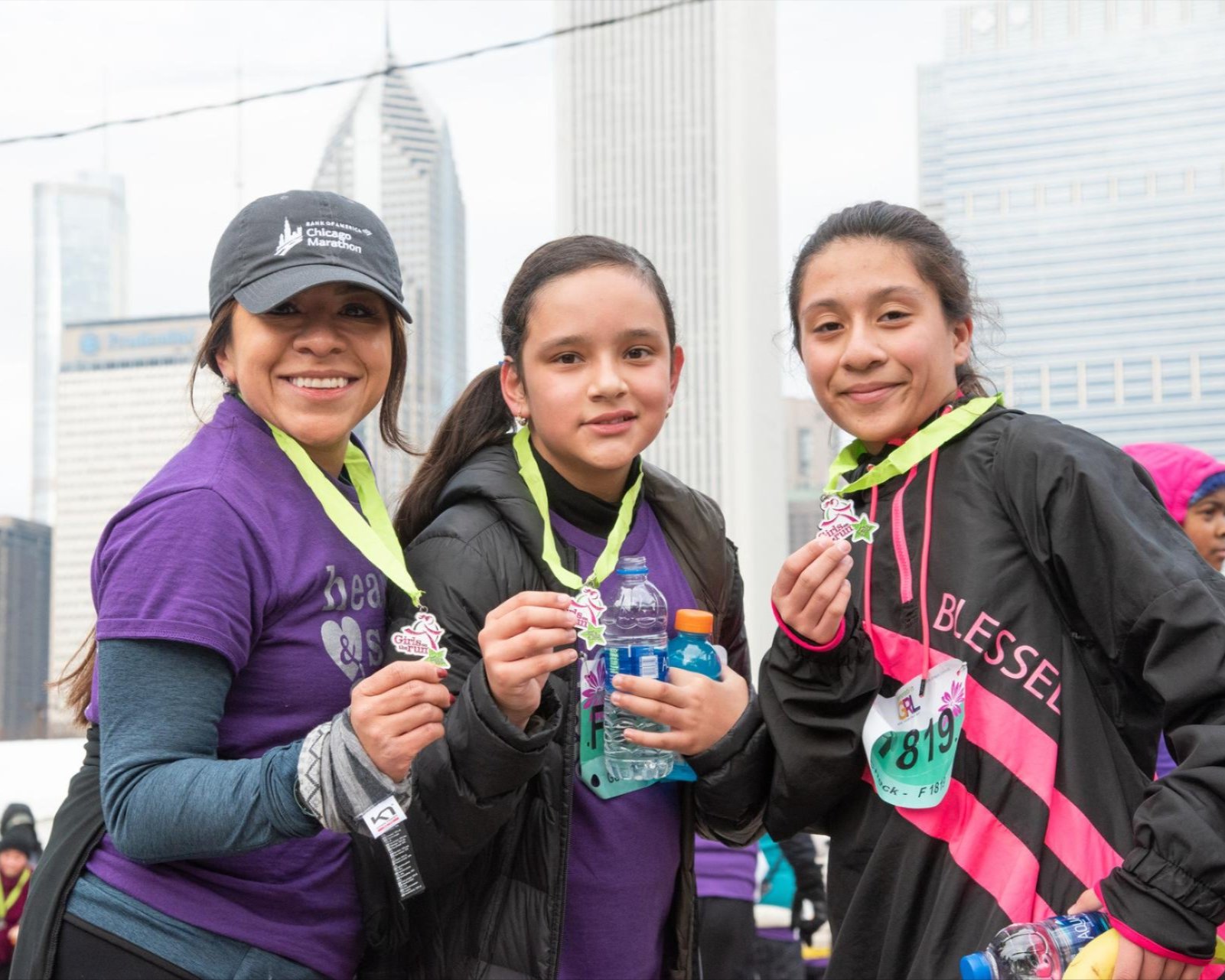 From left to right: Coach Edy, another participant, and Daniela posing with their medals at the GOTRC 5K in 2019